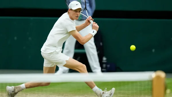 Tennis player in action, about to swing the bat.